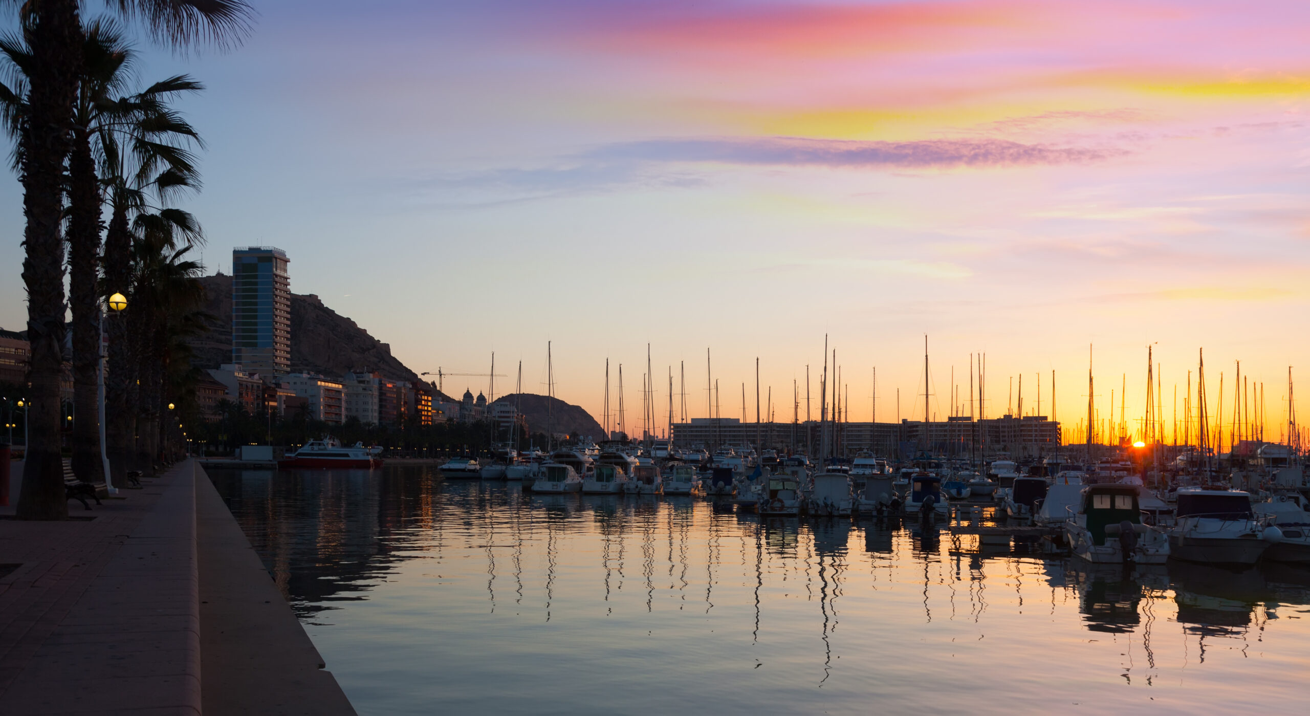 Port with yachts and embankment in sunrise. Alicante